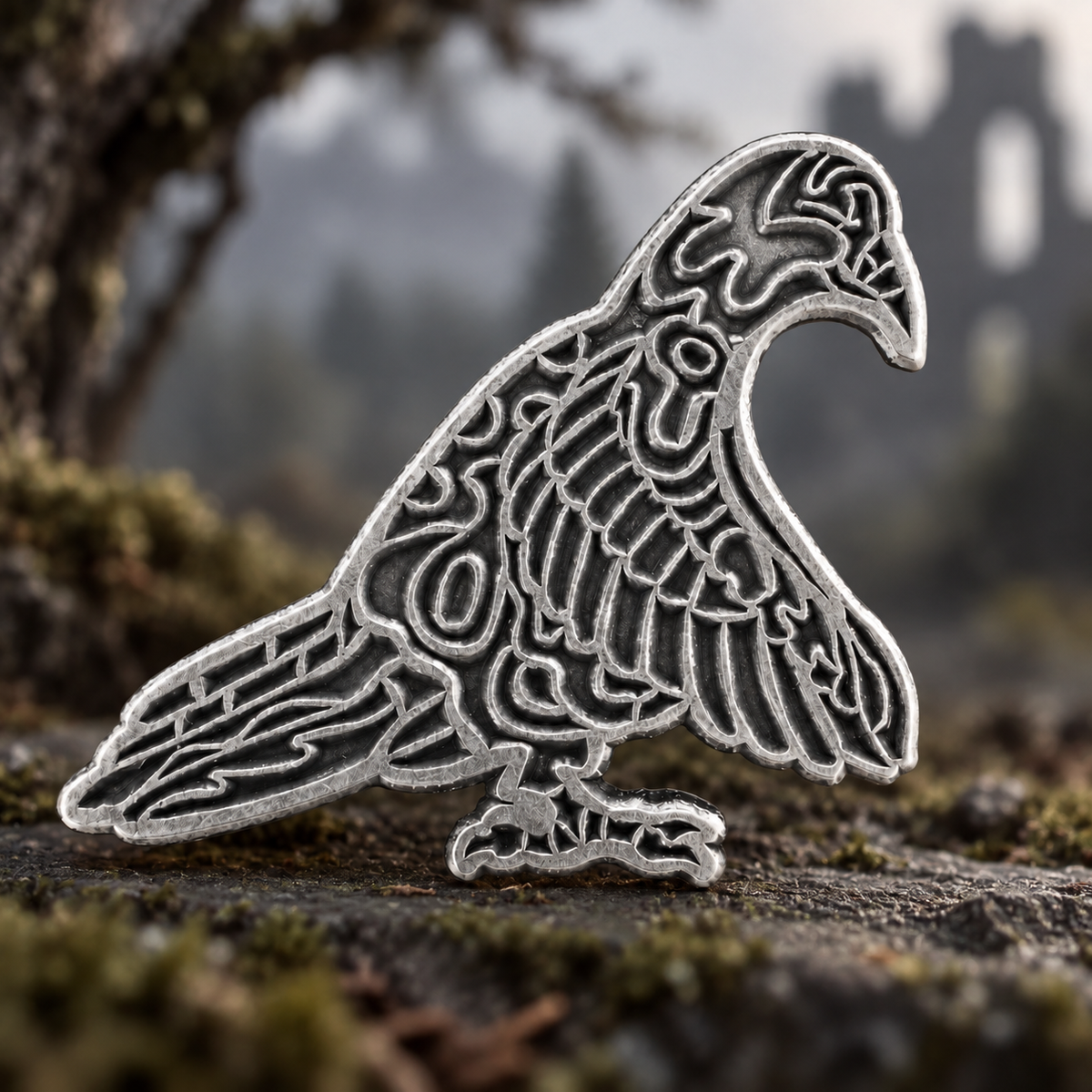 Interlaced patterns and feather details define a raven silhouette in antique silver-tone metal