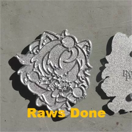 Raw metal stampings of the enamel pins before plating or enamel application, showing clean outlines and mold accuracy.